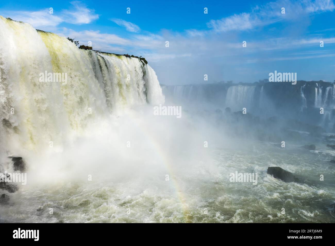 Die Iguazu-Wasserfälle mit Wolken und blauer Himmel im Hintergrund in Foz do Iguaçu, Brasilien Stockfoto