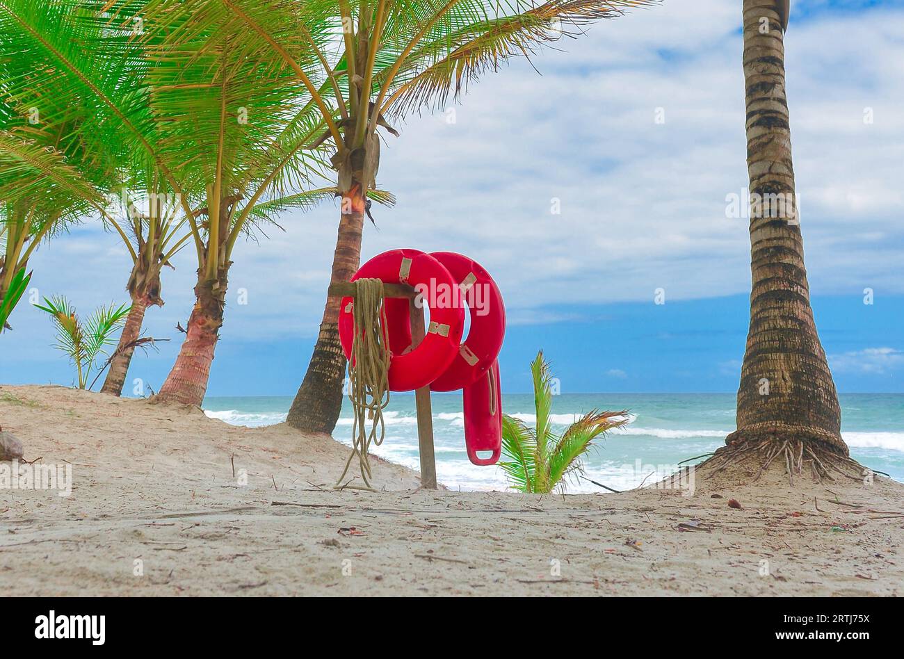 Rote lebendige Boje am Strand mit hellem Sand und blauem Himmel im Hintergrund Stockfoto