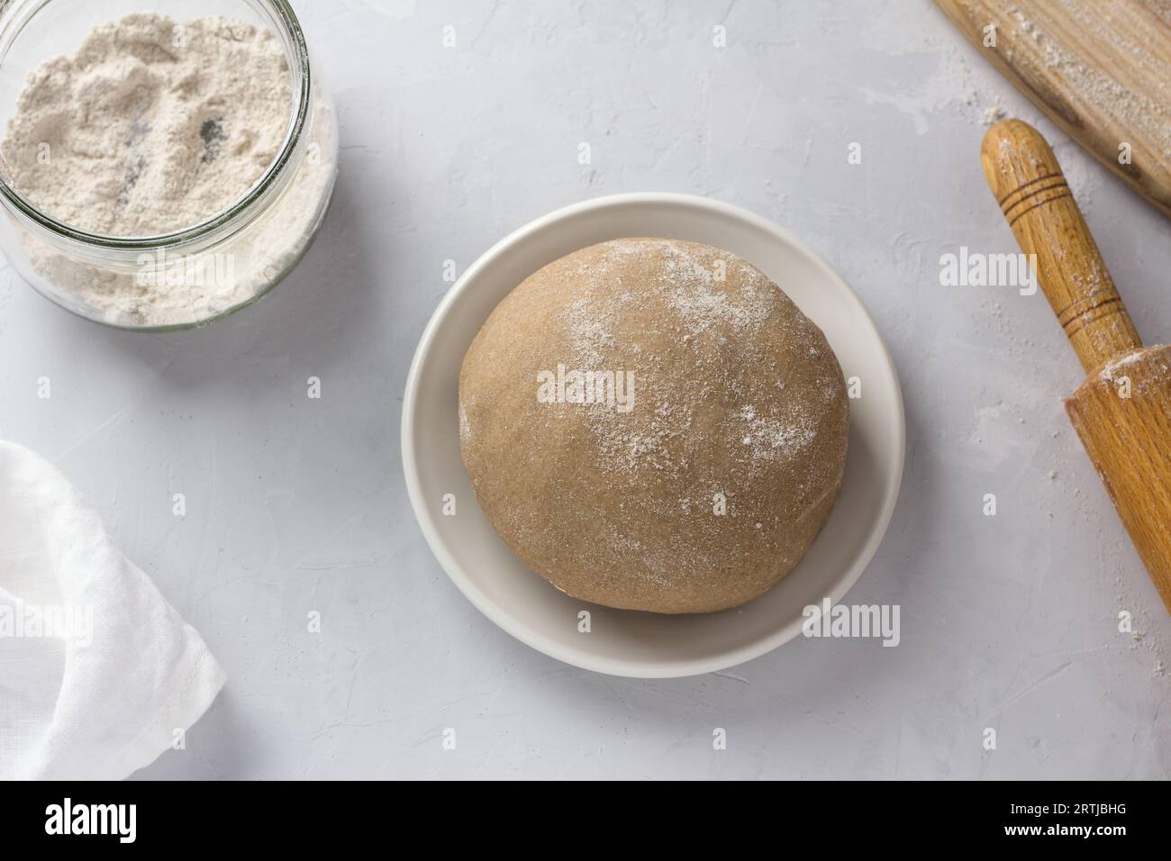 Roggenteig für Torten, Roggenmehl und Rollnadel auf grauem Hintergrund, Draufsicht. Kochbühne. Stockfoto