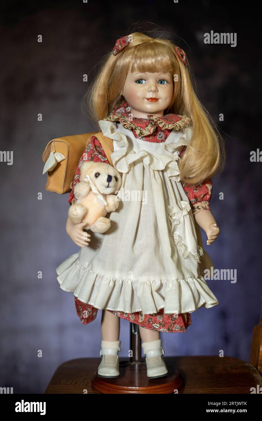 Realistisches Porzellan, antike Vintage-Puppe oder -Spielzeug, blondes Haar und Vintage-Kleid. Stockfoto