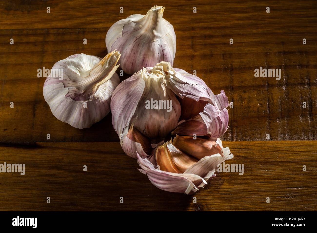 Goiania, Goias, Brasilien – 24. Mai 2023: Knoblauchköpfe auf einem Holztisch mit glänzender Oberfläche, von oben fotografiert. Stockfoto