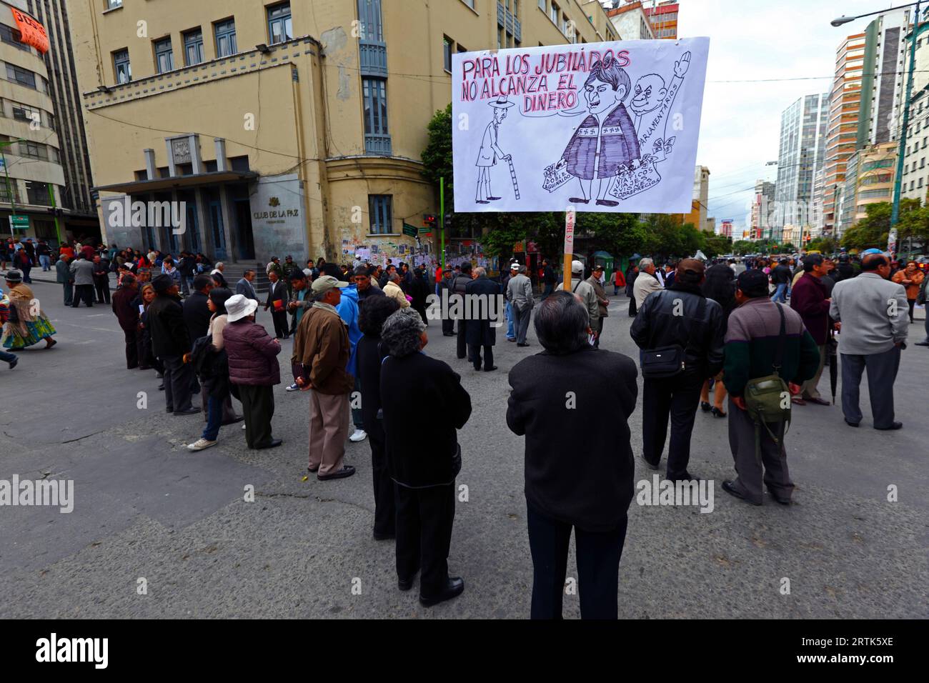 Pensionierte Lehrer halten eine Karikatur des bolivianischen Präsidenten Evo Morales Ayma, der an einer Straßensperre im Stadtzentrum Taschen mit Bargeld hält, während eines Protestes, der eine Erhöhung ihrer Renten fordert, La Paz, Bolivien. Stockfoto