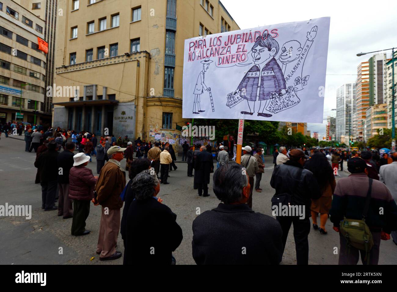 Pensionierte Lehrer halten eine Karikatur des bolivianischen Präsidenten Evo Morales Ayma, der an einer Straßensperre im Stadtzentrum Taschen mit Bargeld hält, während eines Protestes, der eine Erhöhung ihrer Renten fordert, La Paz, Bolivien. Stockfoto