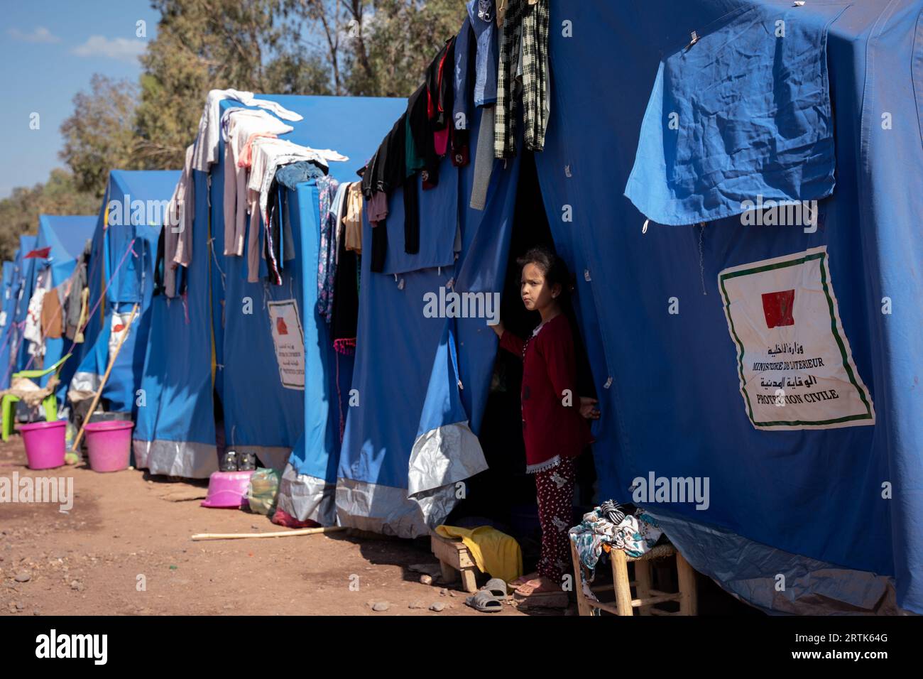 Marokko. September 2023. Ein Mädchen steht vor einem Zelt und dient als provisorisches Zuhause für Menschen, die ihre Häuser durch das Erdbeben verloren haben. Die Dorfbewohner in Imlil in den Toubkal-Bergen kommen noch immer mit der Zerstörung zurecht, die das Erdbeben am vergangenen Freitag angerichtet hat. Da viele Häuser beschädigt oder zerstört wurden, wurden Dorfbewohner in Zelte verlegt und werden von Ärzten aus einem nahe gelegenen Militärkrankenhaus in Asni betreut, wo täglich etwa 600 Menschen behandelt werden. Fast 3.000 Menschen sollen bei dem Erdbeben ums Leben gekommen sein. (Bild: © Ashley Chan/SOPA Images über ZUMA Press Stockfoto