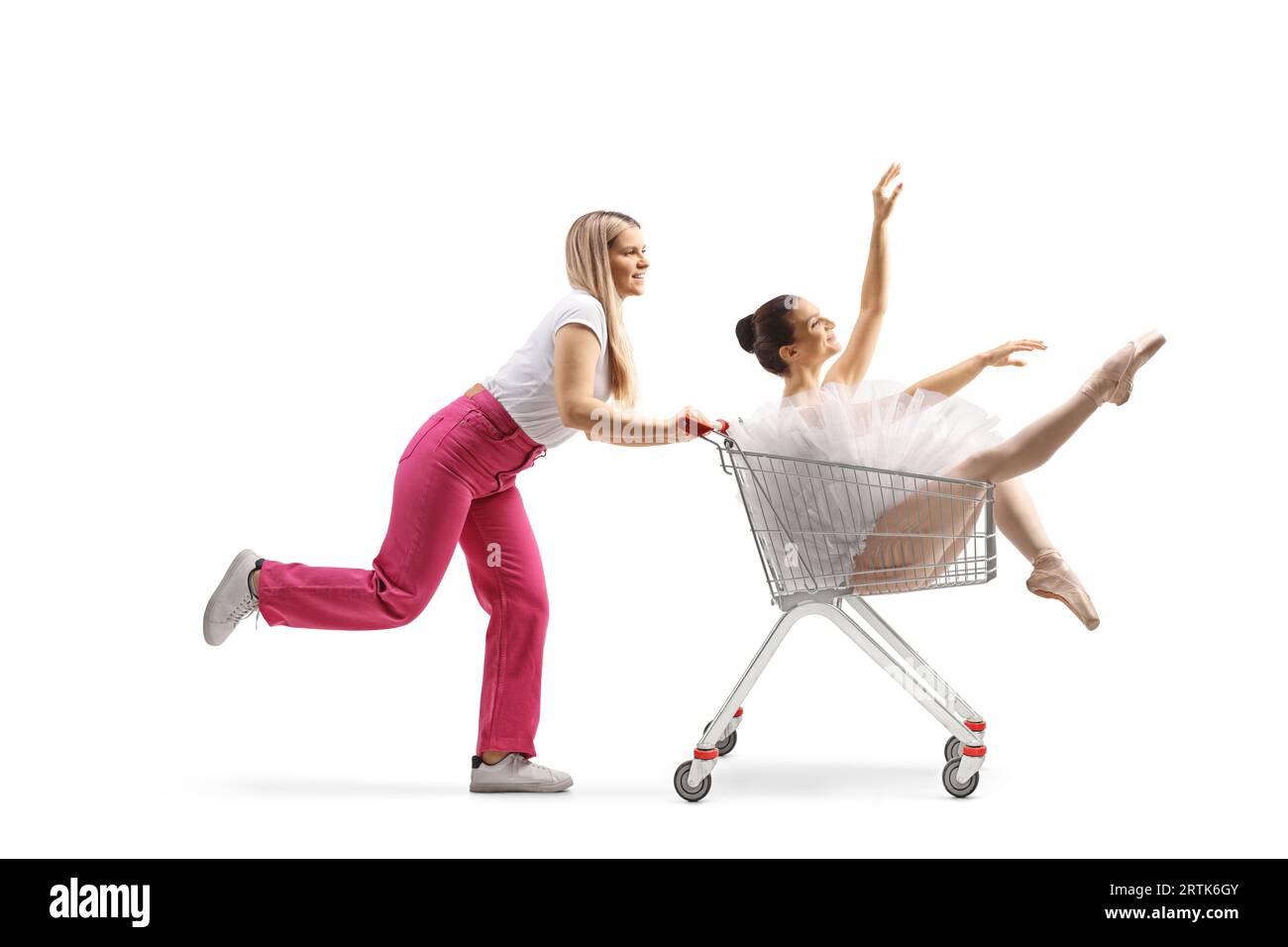 Junge Frau läuft und schiebt eine Ballerina in einen Einkaufswagen, isoliert auf weißem Hintergrund Stockfoto