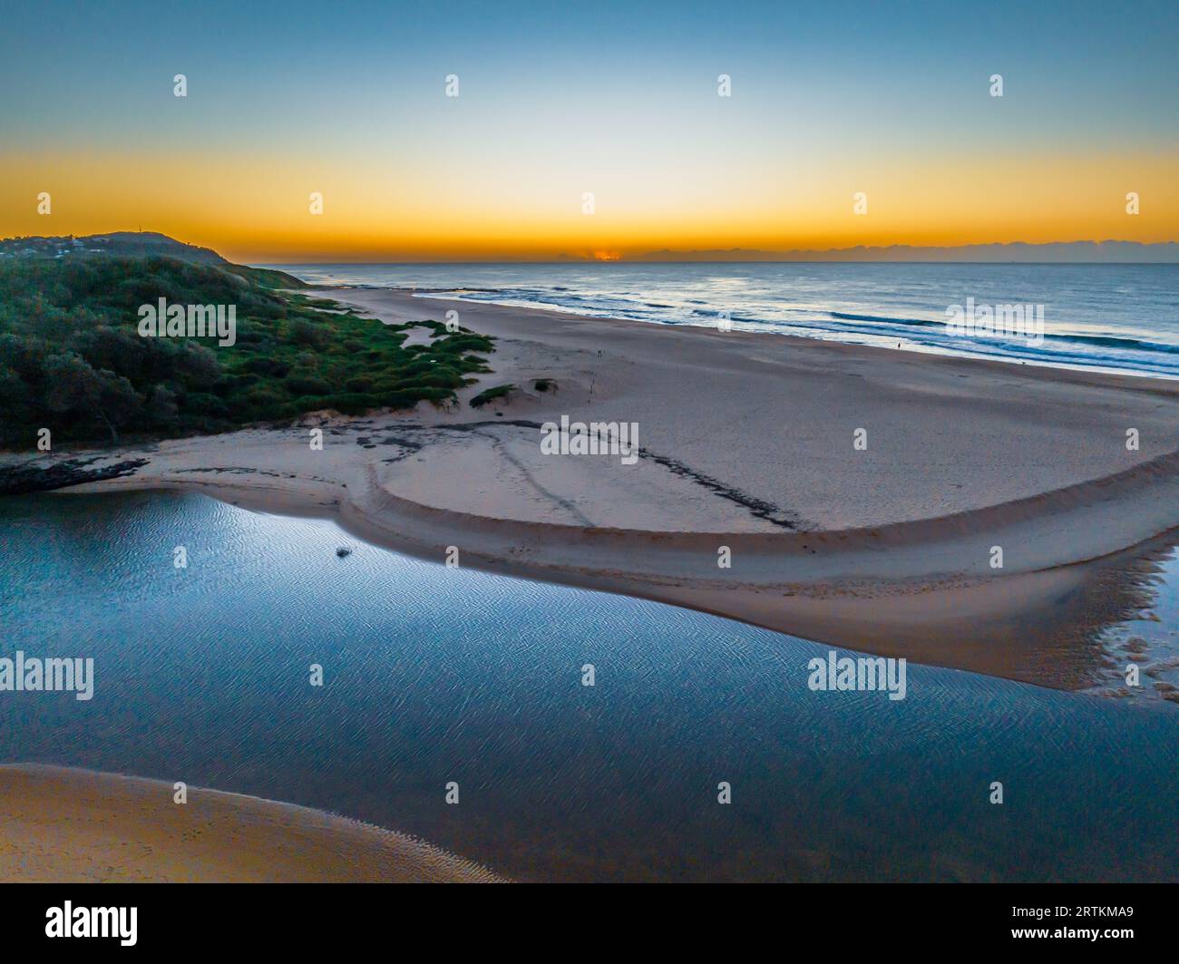 Sonnenaufgang aus der Luft mit der zum Meer offenen Lagune am Wamberal Beach an der Central Coast, NSW, Australien. Stockfoto