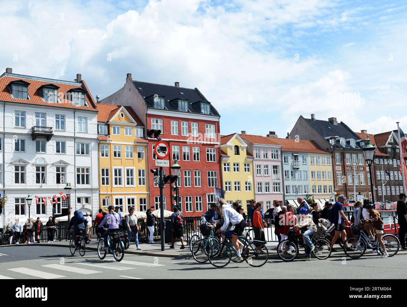 Touristen und Einheimische radeln am Nyhavn-Kanal in Kopenhagen, Dänemark. Stockfoto