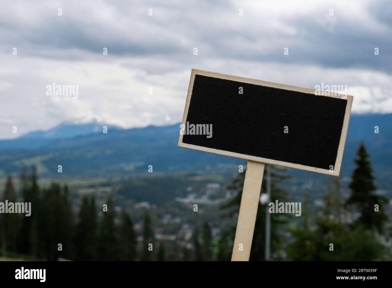 Leeres Tafeletikett mit Kopierfeld auf dem Hintergrund der schneebedeckten Berge, grüne Wälder im Nationalpark Zakopane Polen. Berglandschaft. Reisen Sie im Freien Grünes Tourismuskonzept Naturecore. Wandern und Wohlbefinden Stockfoto