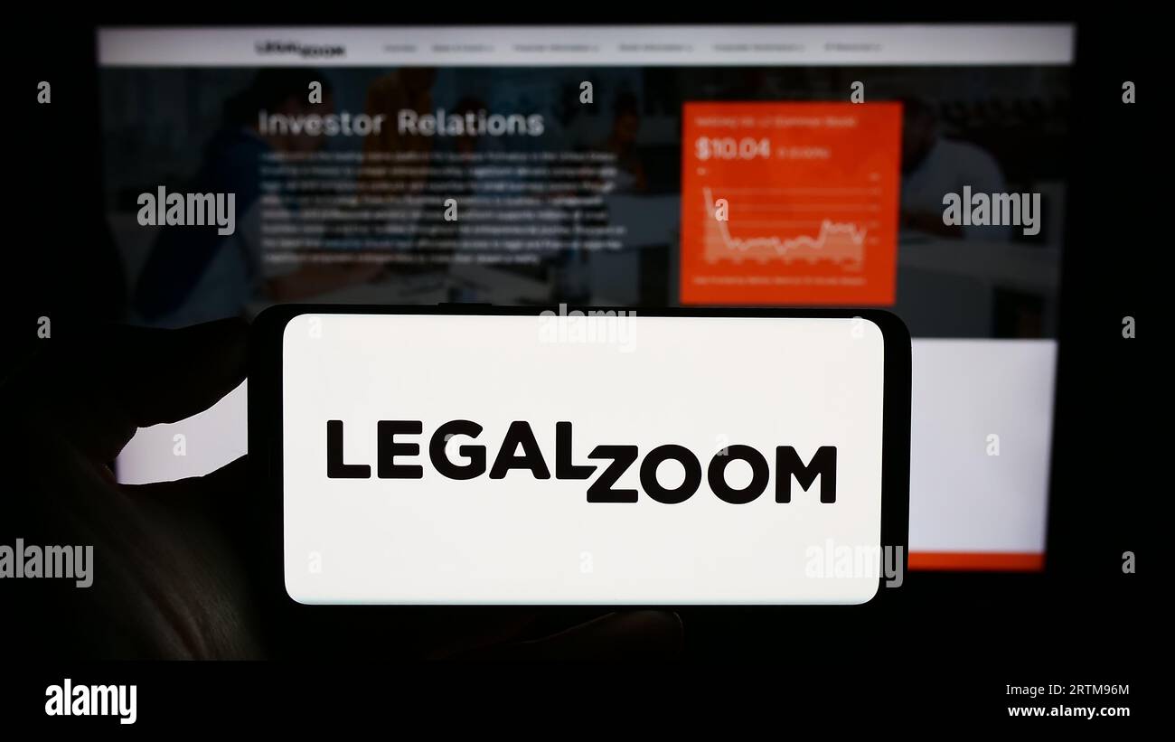 Person, die ein Mobiltelefon mit dem Logo des US-amerikanischen Legal-Technology-Unternehmens LegalZoom.com Inc. Auf dem Bildschirm vor der Webseite hält. Konzentrieren Sie sich auf das Display des Telefons. Stockfoto