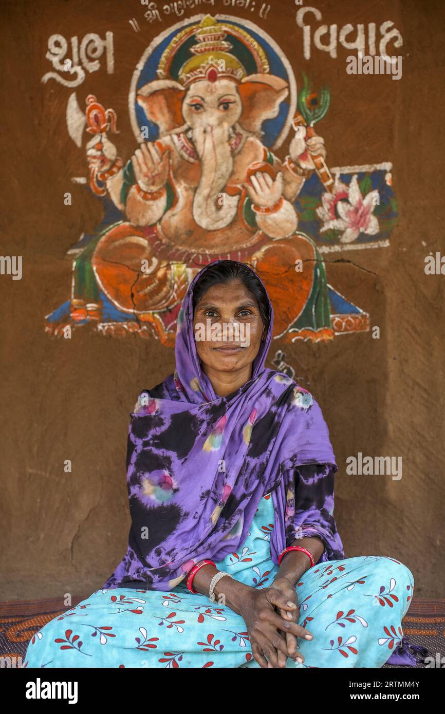 Adivasi-Frau sitzt vor ihrem Haus im Bezirk Narmada, Gujarat, Indien Stockfoto