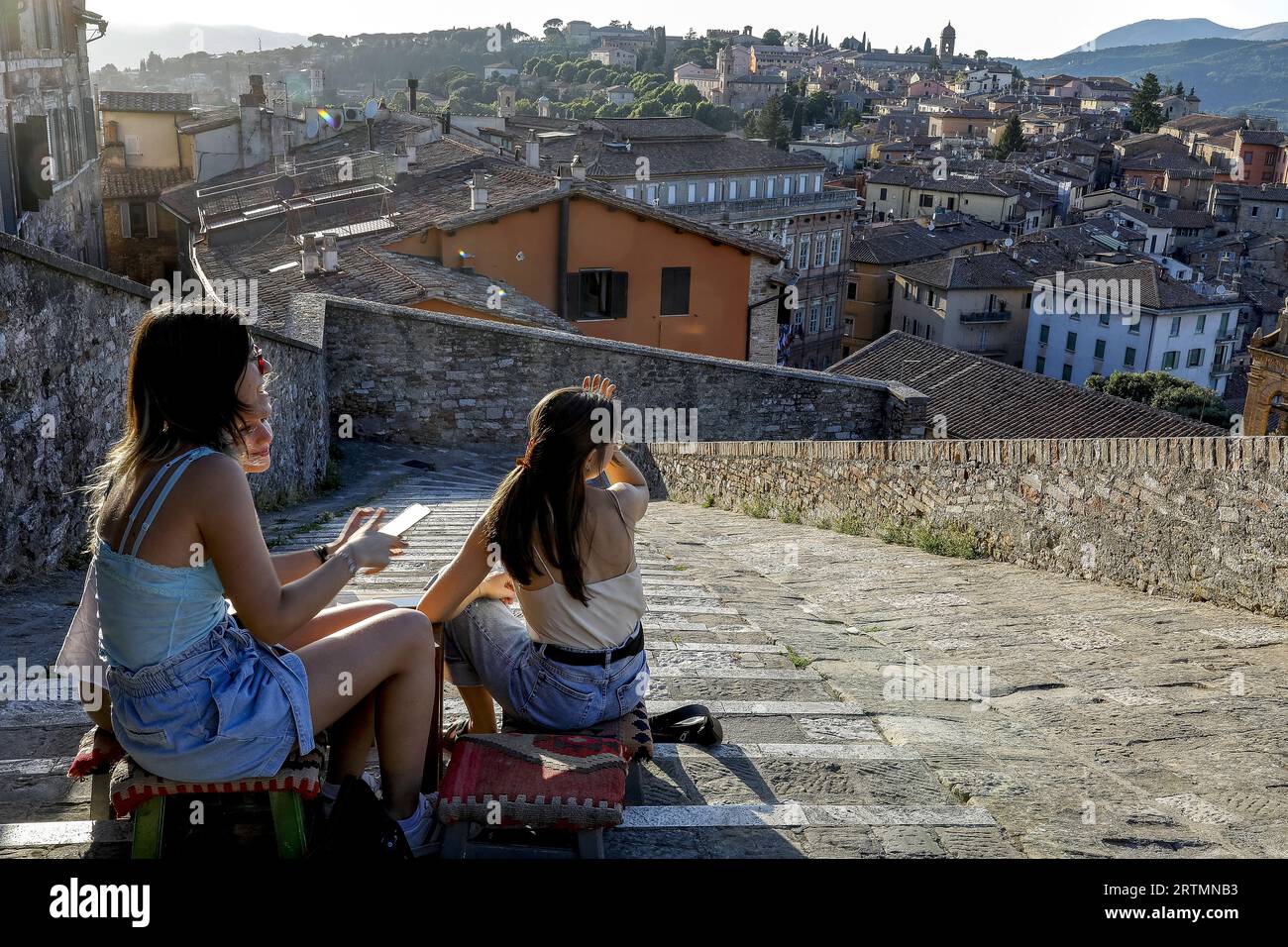 Junge Frauen sitzen in einer Bar auf einer städtischen Treppe in Perugia, Umbrien, Italien Stockfoto