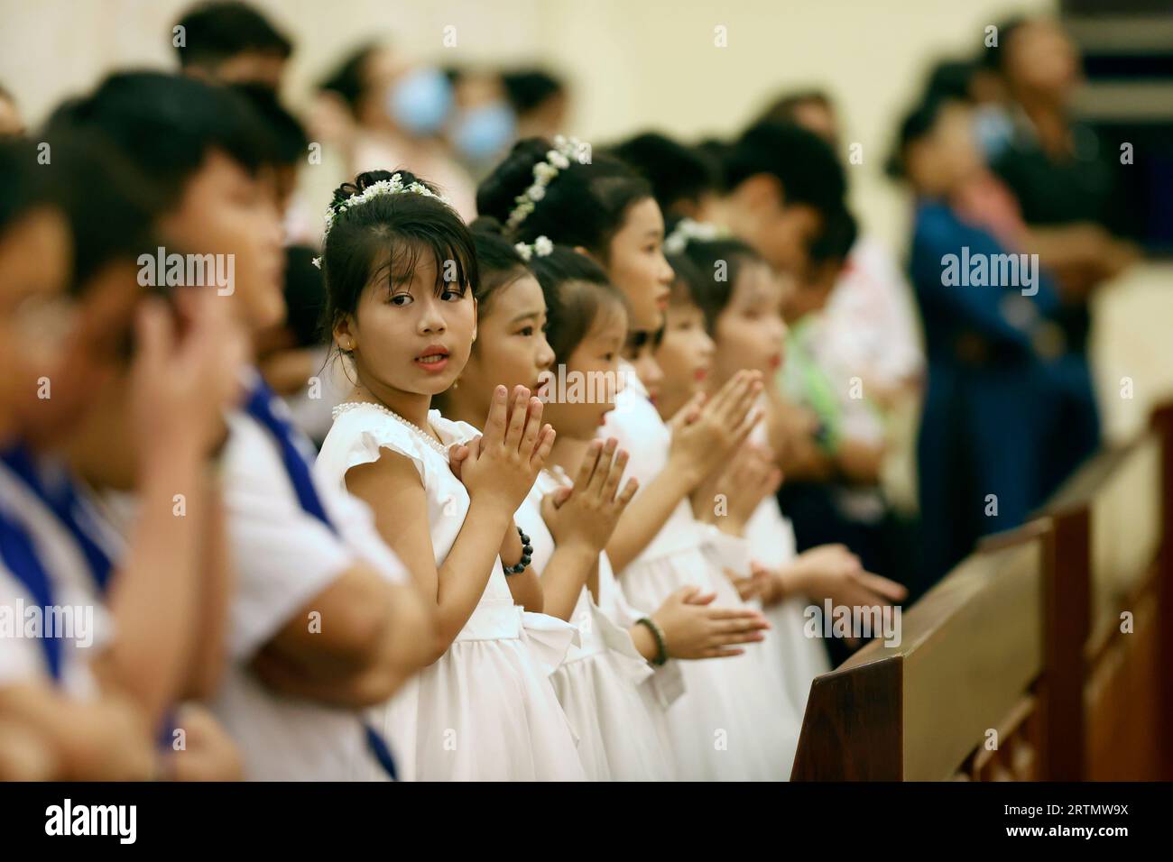 Song Vinh katholische Kirche. Kinder während der Heiligen Donnerstagsmesse. Der Heilige Donnerstag ist das Gedenken an das Letzte Abendmahl Jesu Christi. Vietnam. Stockfoto