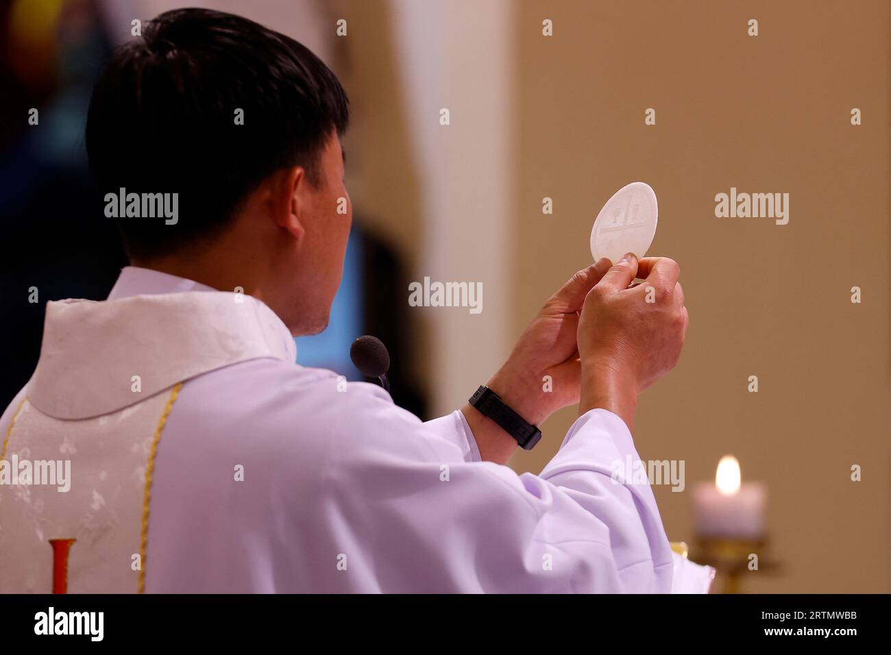 St. Nikolaus Kathedrale Dalat. Sonntagsmesse. Rückansicht des Priesters mit keule bei der eucharistiefeier. Erhöhung des Hosts. Dalat. Vietnam. Stockfoto
