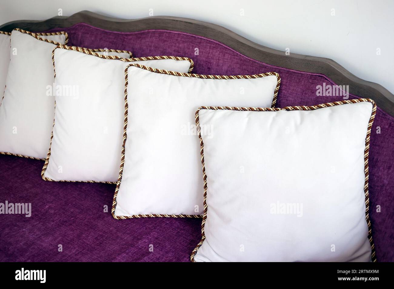 Weiße Kissen auf einem lilafarbenen Sofa. Wohnaccessoires. Stockfoto