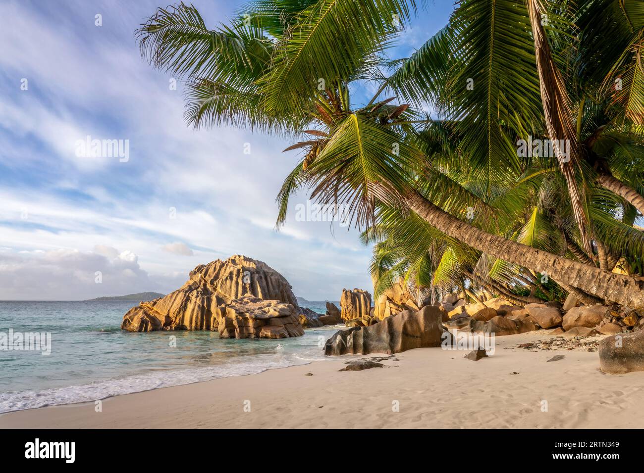 Granitfelsen und Palmen am malerischen tropischen Sandstrand Anse Patates, La Digue Island, Seychellen Stockfoto