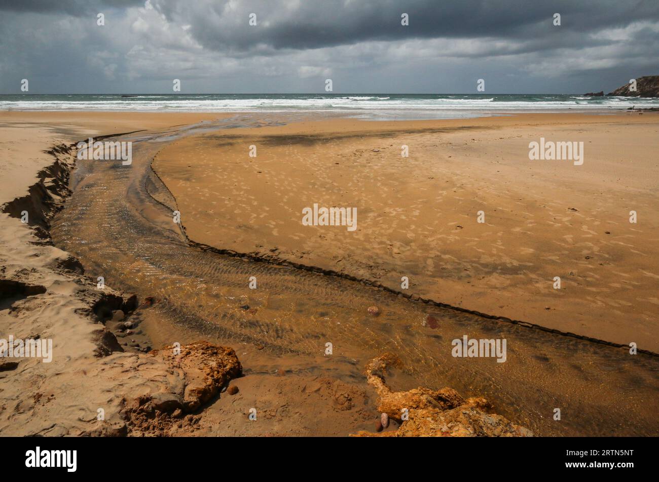 Fluss an einem Strand bei Ebbe in Algarve, Portugal Stockfoto