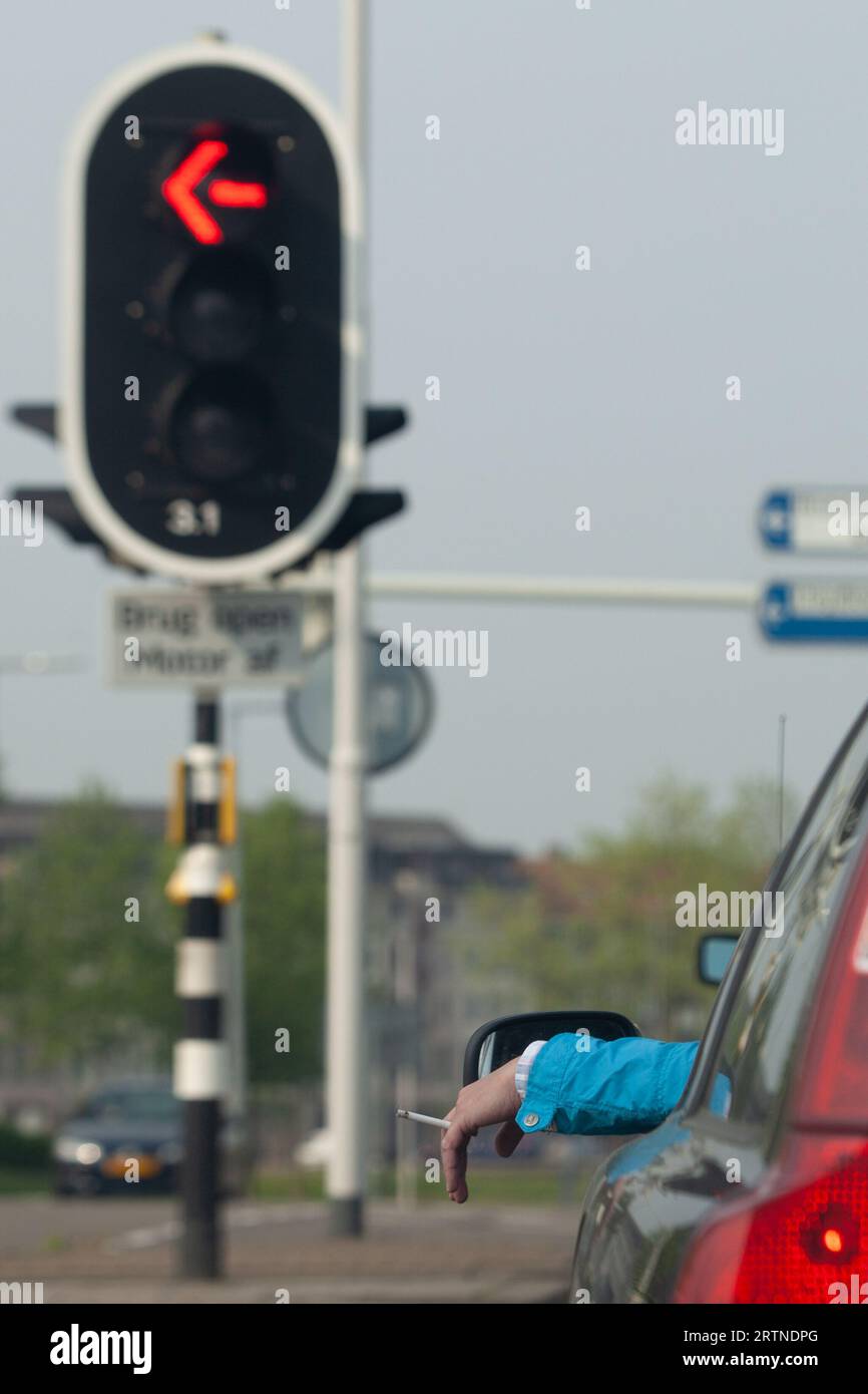 Zwangloses Rauchen einer Zigarette an einer roten Ampel in einem volvo. Stockfoto