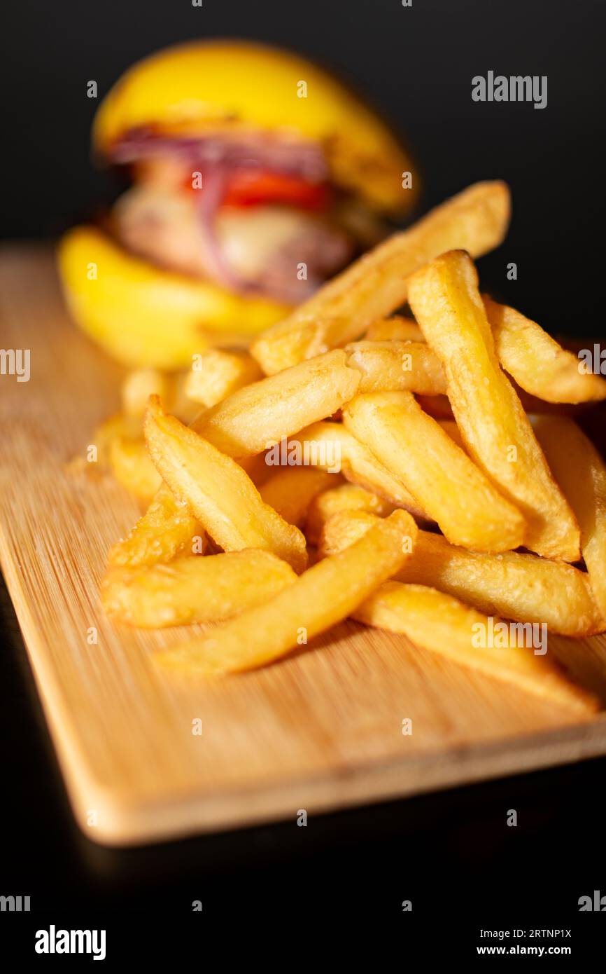 Gelber Mini Gourmet Burger mit französischen Pommes Frites auf Holzbrett Stockfoto