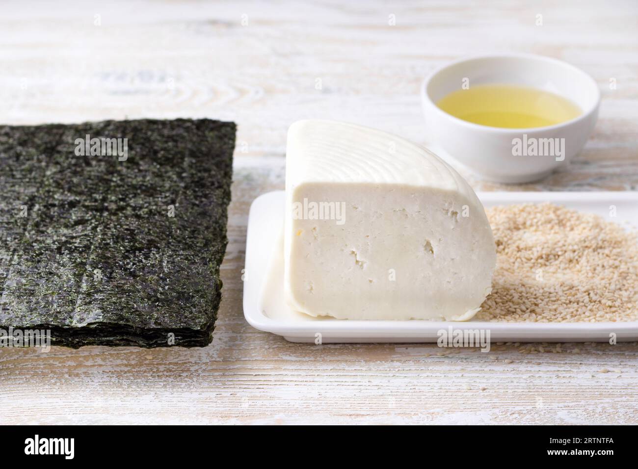 Frischkäse, Nori, Sesamsamen und Pflanzenöl – Zutaten für die Zubereitung eines köstlichen vegetarischen Gerichts. Stockfoto