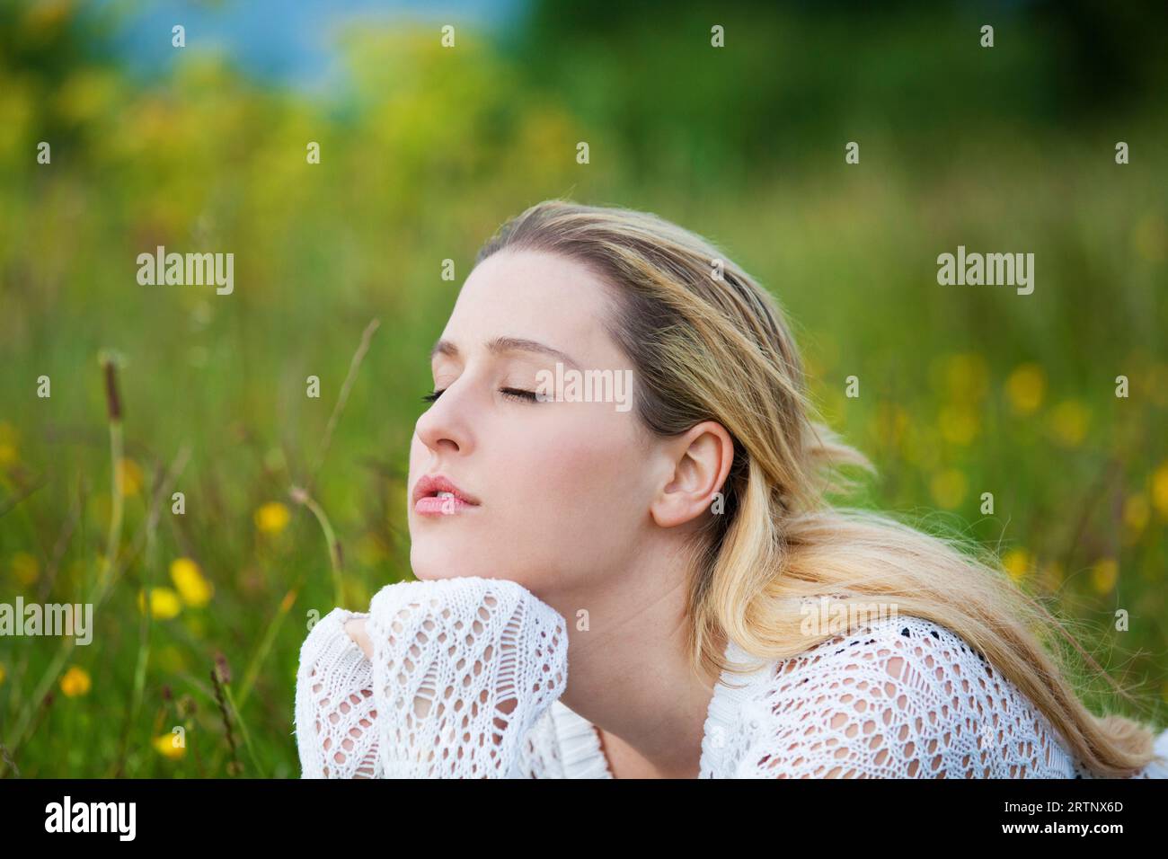 Junge Dame, die frische Luft auf dem Feld atmet Stockfoto