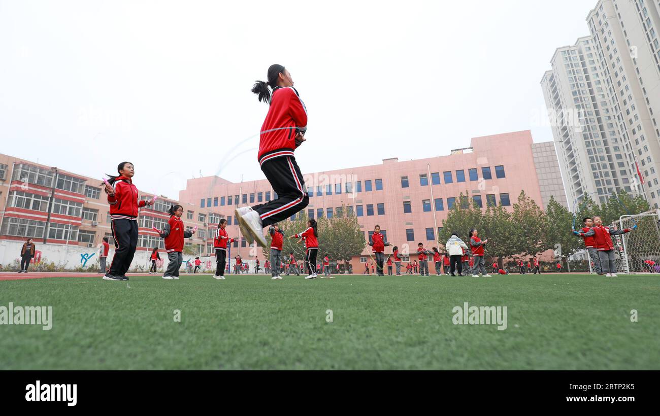 LUANNAN COUNTY, China - 3. November 2021: Grundschüler üben Seilspringen auf dem Spielplatz in Nordchina Stockfoto