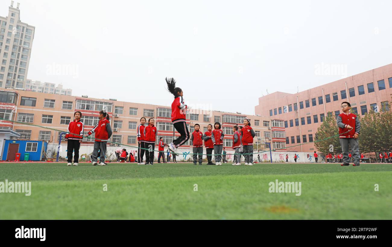 LUANNAN COUNTY, China - 3. November 2021: Grundschüler üben Seilspringen auf dem Spielplatz in Nordchina Stockfoto