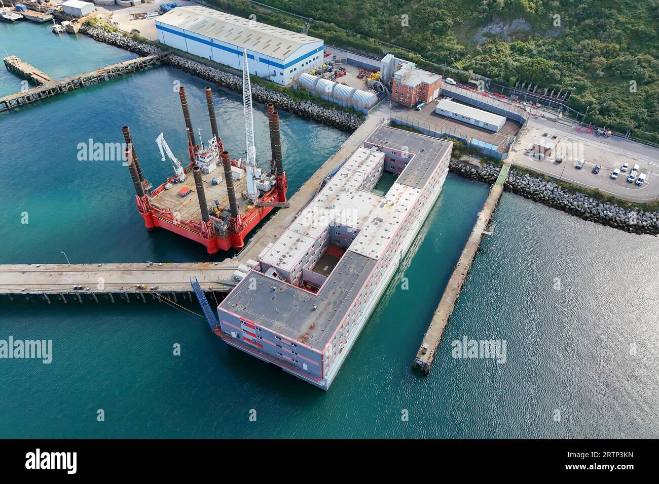 Portland, Dorset, Großbritannien. 14. September 2023. Allgemeine Sicht aus der Luft des Lastkahns für Asylbewerber in Bibby Stockholm am Hafen von Portland bei Weymouth in Dorset, wo aufgrund anhaltender Brandschutzbedenken an Bord eine neue blaue Notausstiegsrampe installiert wurde; da Vorbereitungen für die Rückkehr von Migranten in den nächsten Wochen getroffen werden. Der Lastkahn sollte über 500 Migranten beherbergen, aber es wurde berichtet, dass diese Zahl aus Sicherheitsgründen gestrichen wurde. Bildnachweis: Graham Hunt/Alamy Live News Stockfoto