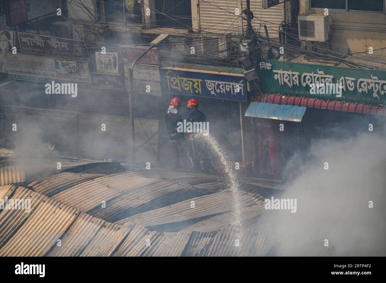 Feuerwehrleute versuchen, ein Feuer zu löschen, das auf dem Mohammadpur Krishi-Markt in Dhaka ausbrach. Ein Brand, der am Mohammadpur Krishi-Markt in der Hauptstadt ausbrach, wurde nach fast sechs Stunden unter Kontrolle gebracht. Insgesamt 217 von 317 zugeteilten Geschäften wurden durch das Feuer beschädigt, das den Mohammadpur Krishi-Markt heute Morgen verwüstete, sagte ein Beamter der Dhaka North City Corporation. Mehrere hundert Händler auf dem Mohammadpur Krishi-Markt in Dhaka beklagen, dass sie bei dem massiven Brand heute Morgen Waren im Wert von mehreren CRS Taka verlieren. Stockfoto