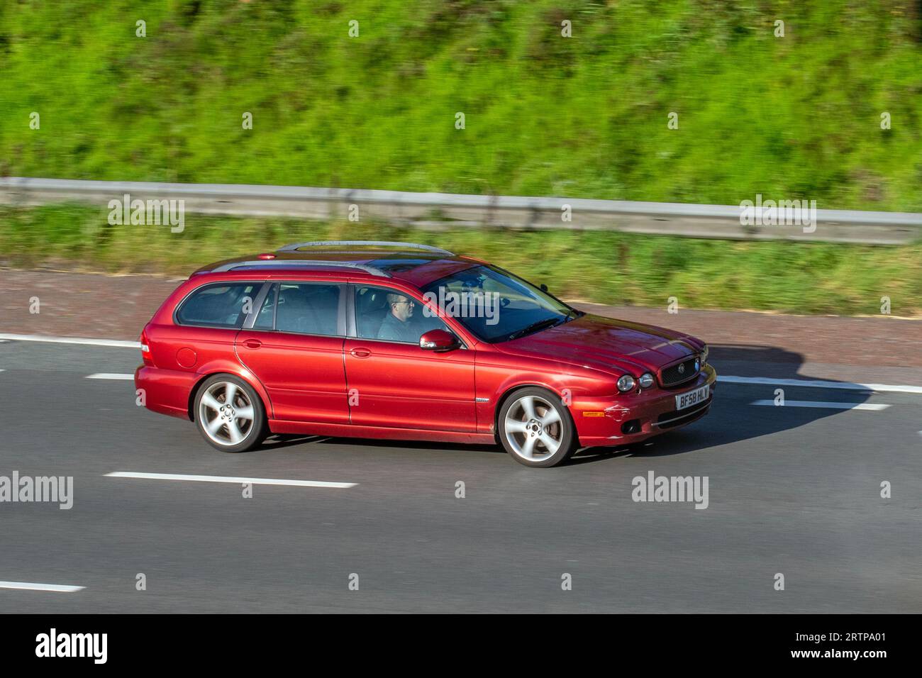 2008 Red Jaguar X-Type Sovereign; Fahrt mit hoher Geschwindigkeit auf der Autobahn M6 im Großraum Manchester, Großbritannien Stockfoto