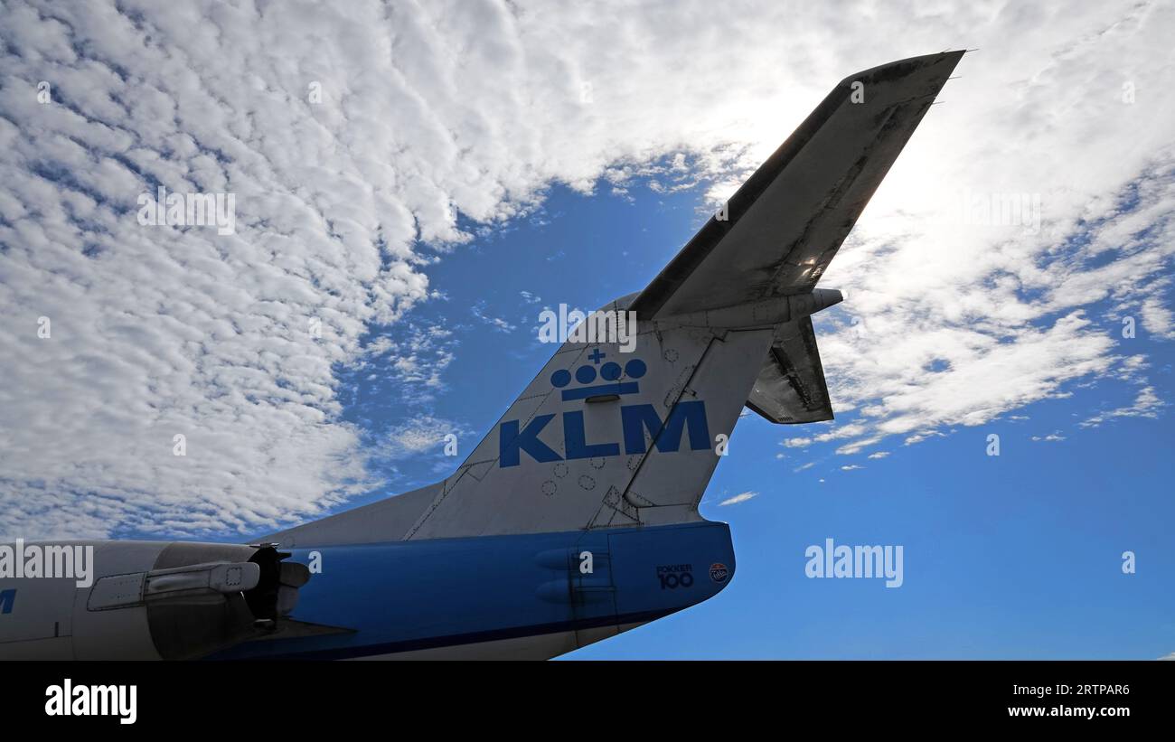 Schiphol, Niederlande - 14. August 2023: Der Schwanz eines Fokker 100 Flugzeugs von KLM gegen einen blauen Himmel mit Wolken Stockfoto