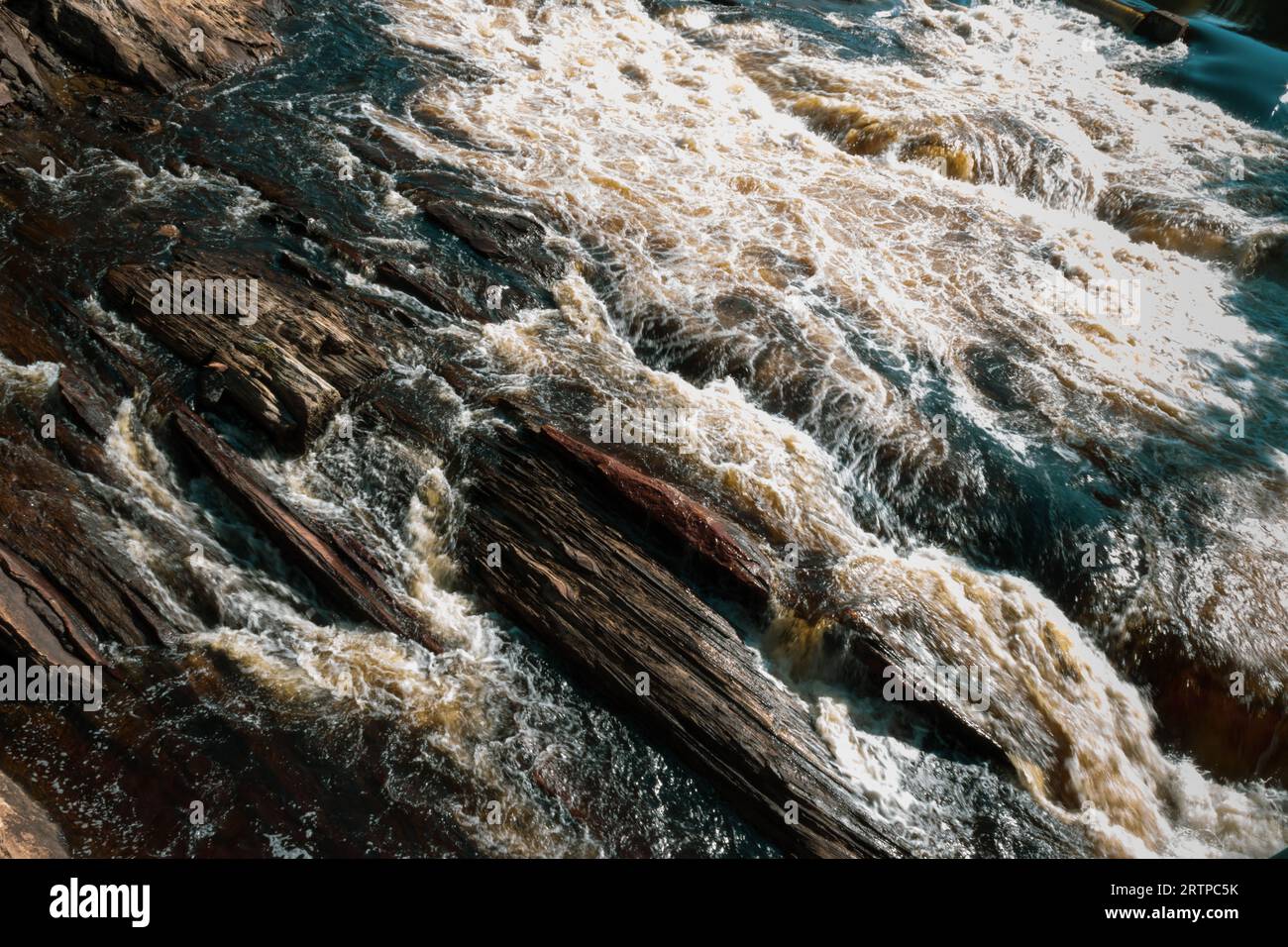 Rapids laufen über Schiefergestein, Schichten, die durch das Schürfen von Wasser sichtbar werden Stockfoto