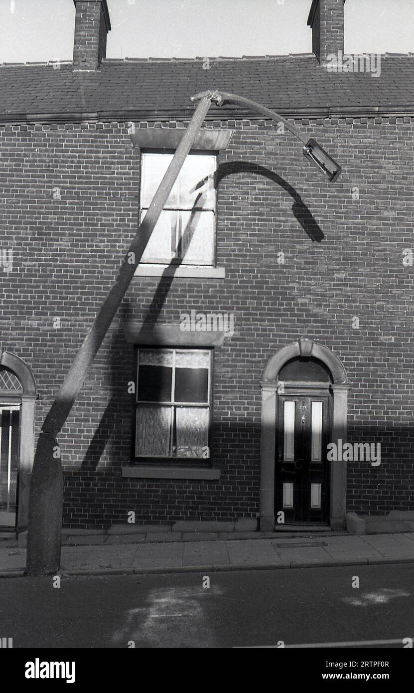 1960er Jahre, historisch, draußen in der Straße von viktorianischen Terrassenhäusern, einem Knicklampenpfosten, Ripponden Rd, Oldham, England, Großbritannien. Stockfoto