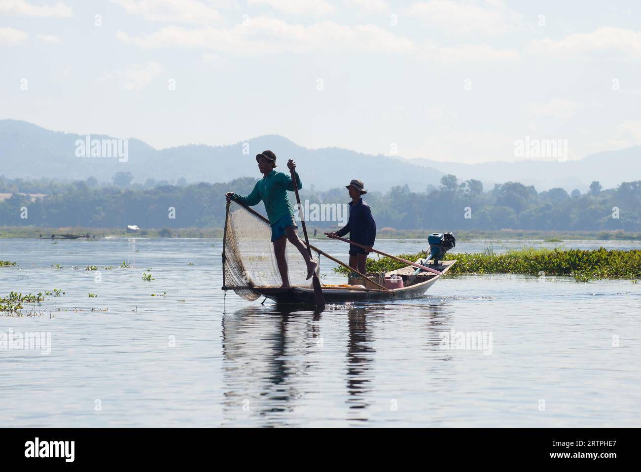 Zwei burmesische Fischer in einem traditionellen Holzboot. Inle Lake, Myanmar Stockfoto