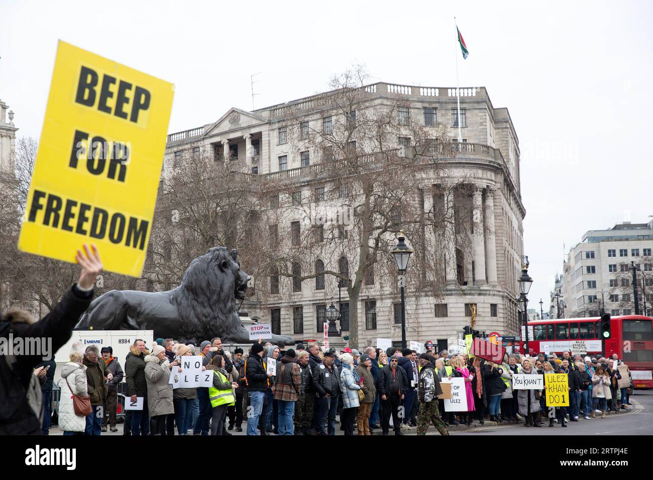 Die Teilnehmer treffen sich mit Plakaten während eines Protestes gegen die Erweiterung der Londoner Umweltzone um den Trafalgar Square in London. Stockfoto