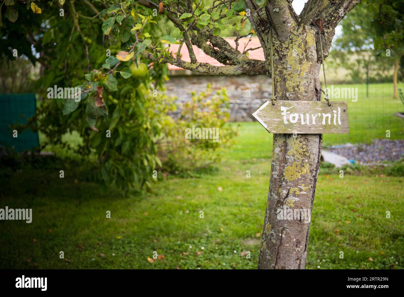 Blick auf den Garten mit einem Pfeilschild „Fournil“, Bäckerei, in Frankreich. Hintergrund oder Hintergrund. Stockfoto