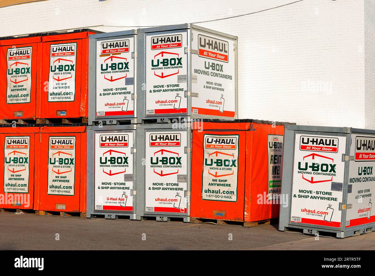 U-Transport-Verleih U-Box Container bewegen, Versandcontainer an einer Wand stapeln. Stockfoto