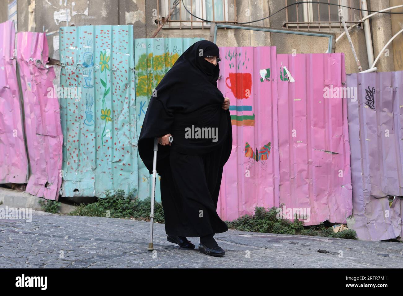 Eine muslimische Frau, die eine Burka trägt, hilft ihr bei ihrem Spaziergang in Istanbul Stockfoto