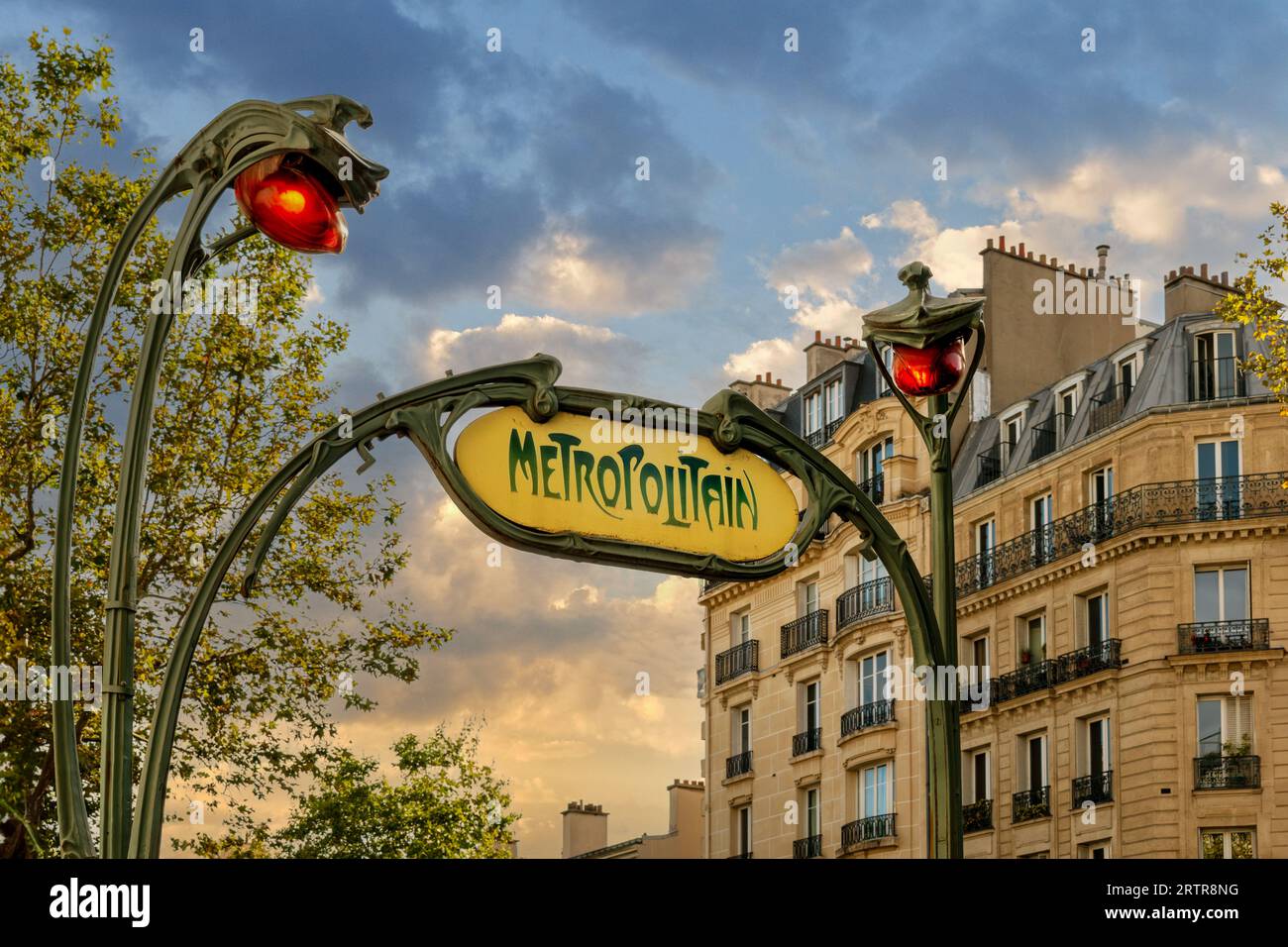 Jugendstilschild mit den charakteristischen roten Straßenlampen der Pariser Metro mit Sonnenuntergang Stockfoto