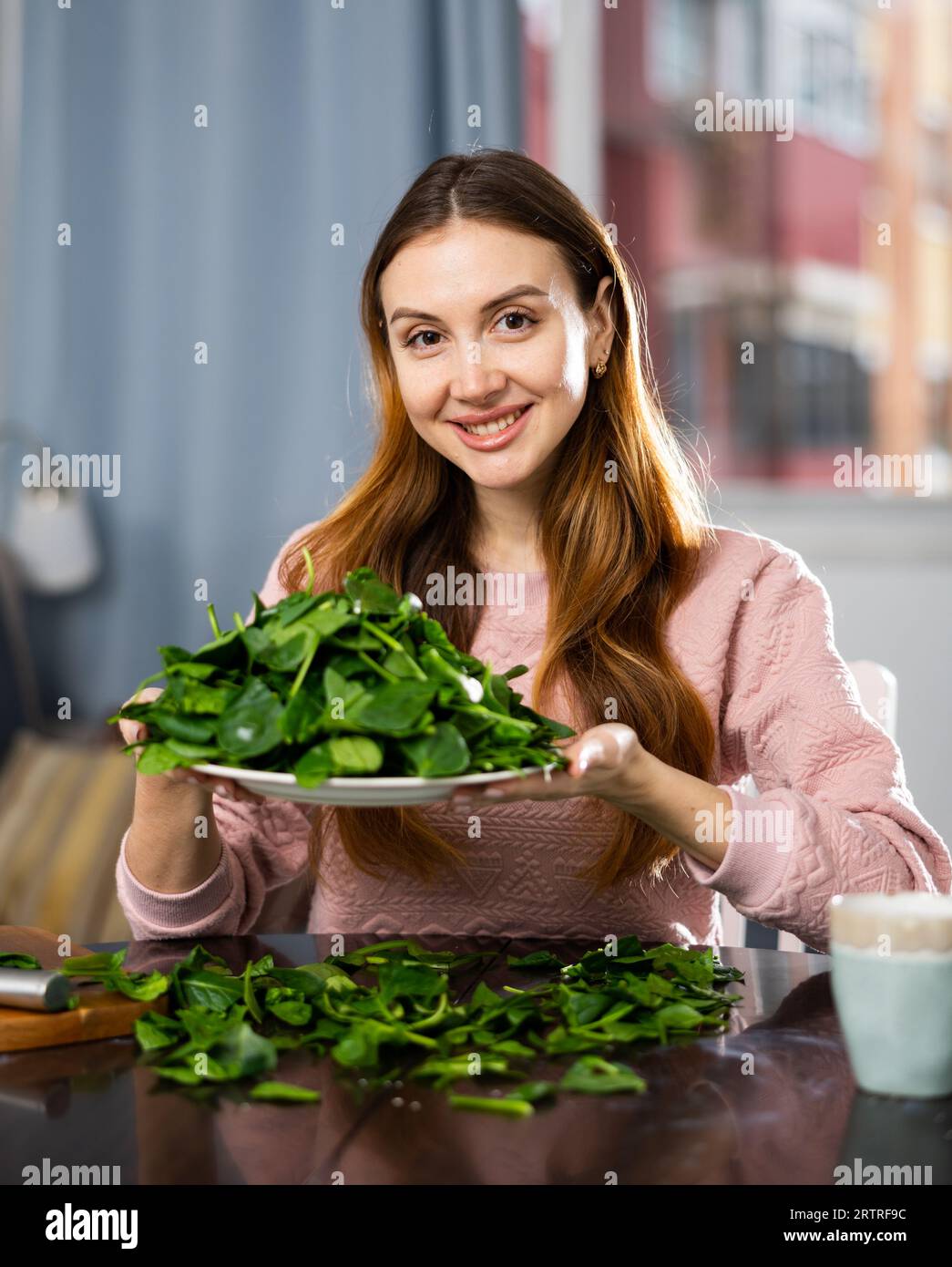 Glückliches Mädchen, das köstlichen Spinatsalat aus der Nähe macht Stockfoto