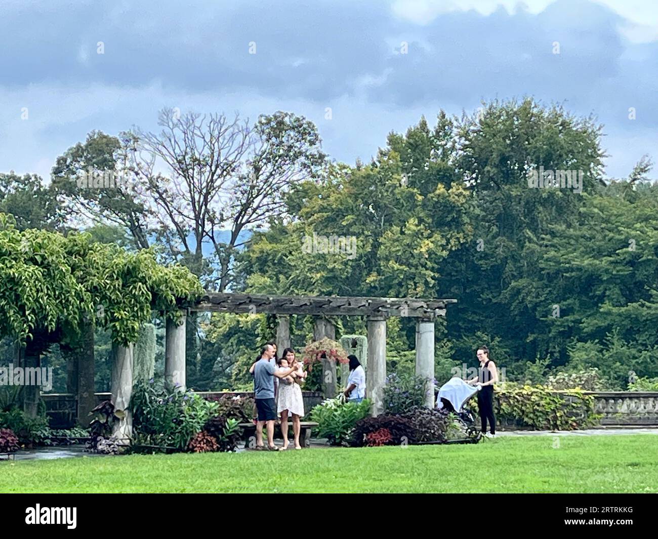 Touristen besuchen die Pergola von Wave Hill. Auf dem großen Rasen. Gelände im Wave Hill Public Garden and Cultural Center, Riverdale, New York, USA. Stockfoto