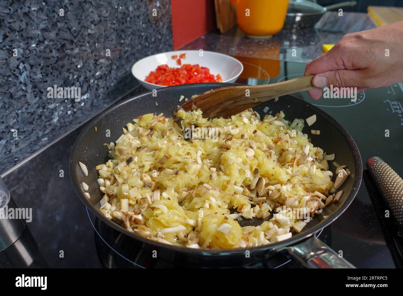 Schwäbische Küche, Zubereitung von deftigem Kartoffelstrudel, geriebenen und gekochten Kartoffeln, Ansaugen von Petersilienwurzel und Pilzen, Herstellung der Füllung, Gemüse Stockfoto