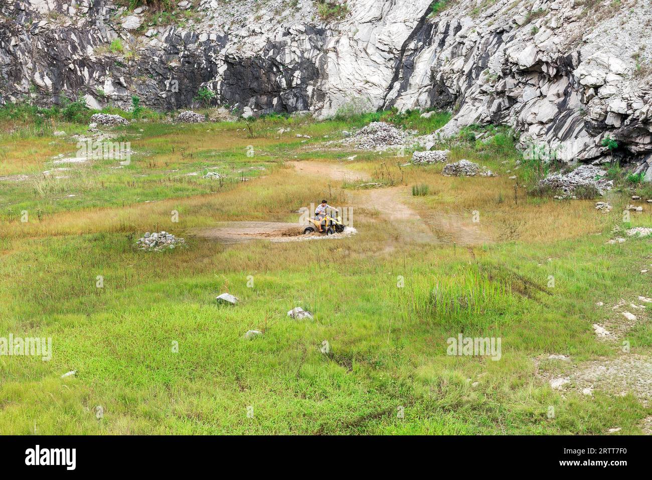 Minas Gerais, Brasilien, 27. Dezember 2015: Man in Nature geht abseits der Straße auf einer Quad-Rallye über Schlamm-Pfützen in der Landschaft Stockfoto