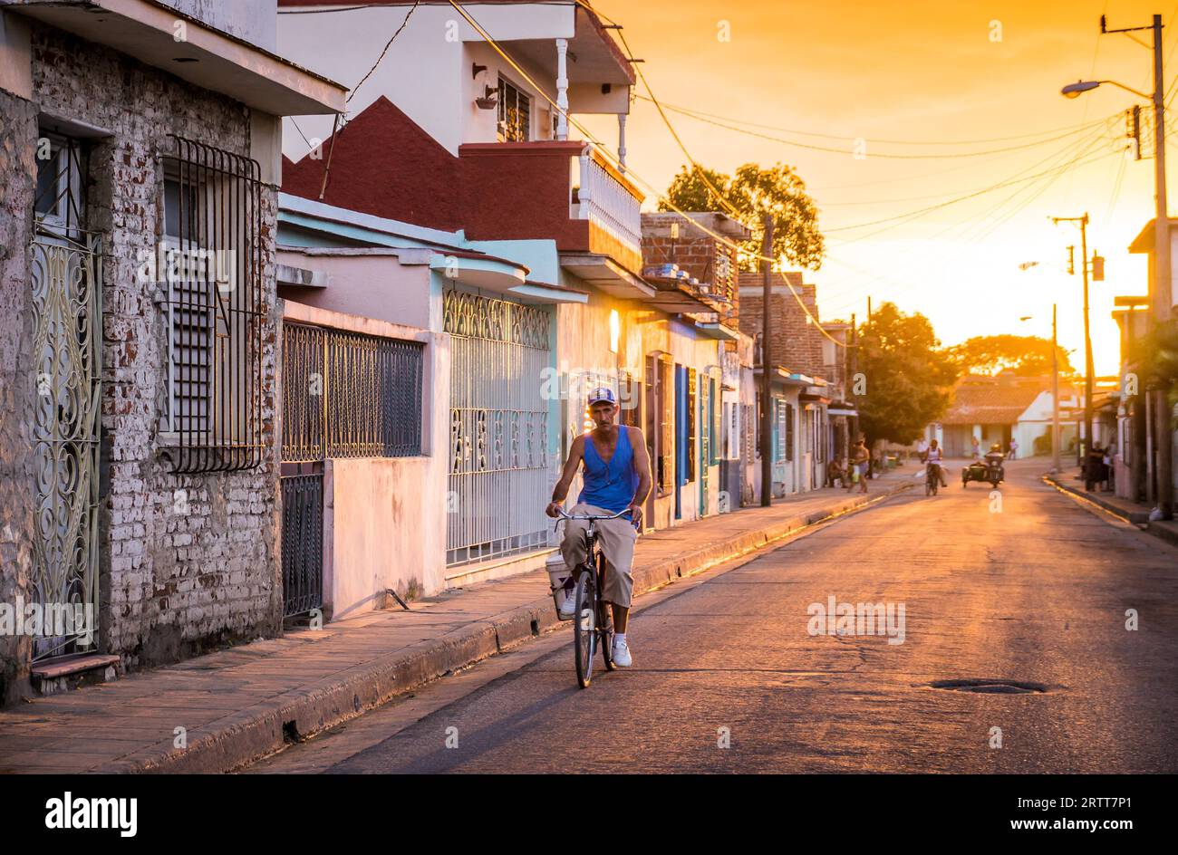 Camagüey, Kuba am 2. Januar 2016: kubanische Mann mit seinem Fahrrad durch eine Straße in der Karibik Altstadt Zentrum von Camagüey bei Sonnenuntergang Stockfoto