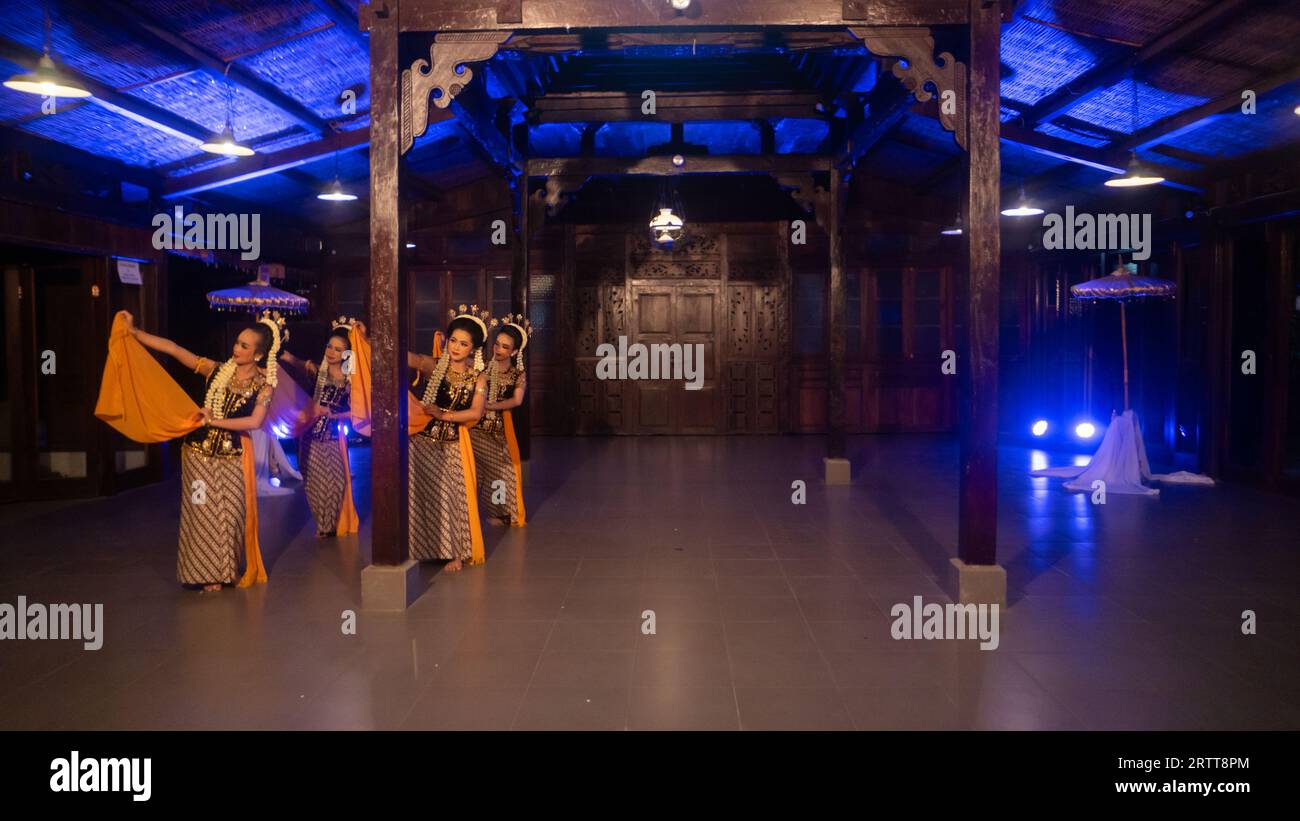 Eine Gruppe javanischer Tänzer tanzt nachts in einem Pavillon mit braunem Holz Stockfoto