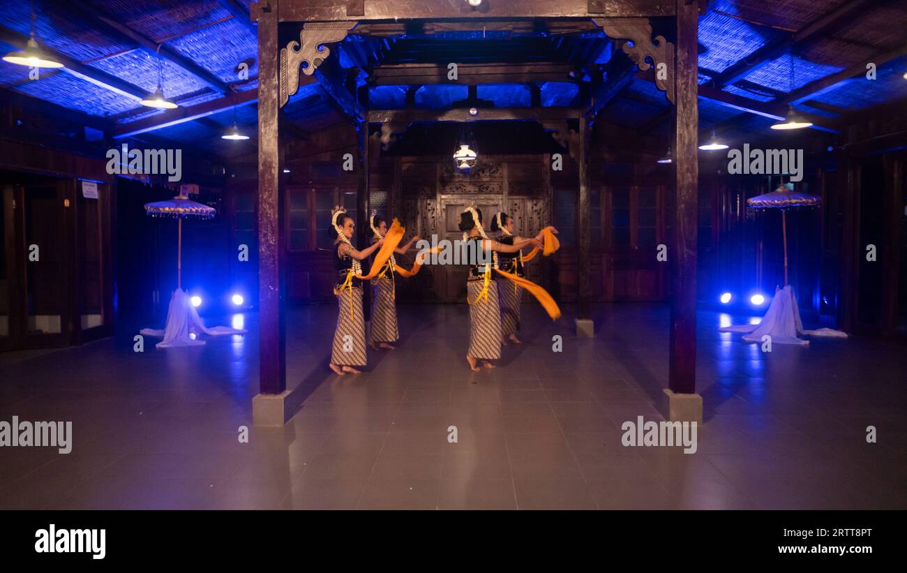 Eine Gruppe javanischer Tänzer tanzt nachts in einem Pavillon mit braunem Holz Stockfoto