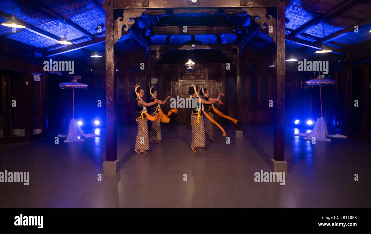 Eine Gruppe javanischer Tänzer tanzt nachts in einem Pavillon mit braunem Holz Stockfoto