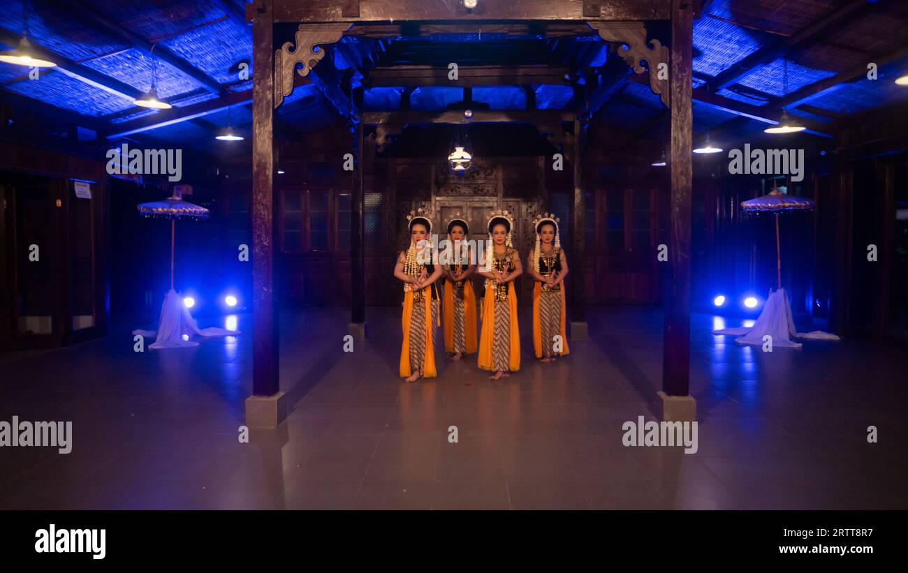 Eine Gruppe javanischer Tänzer tanzt nachts in einem Pavillon mit braunem Holz Stockfoto