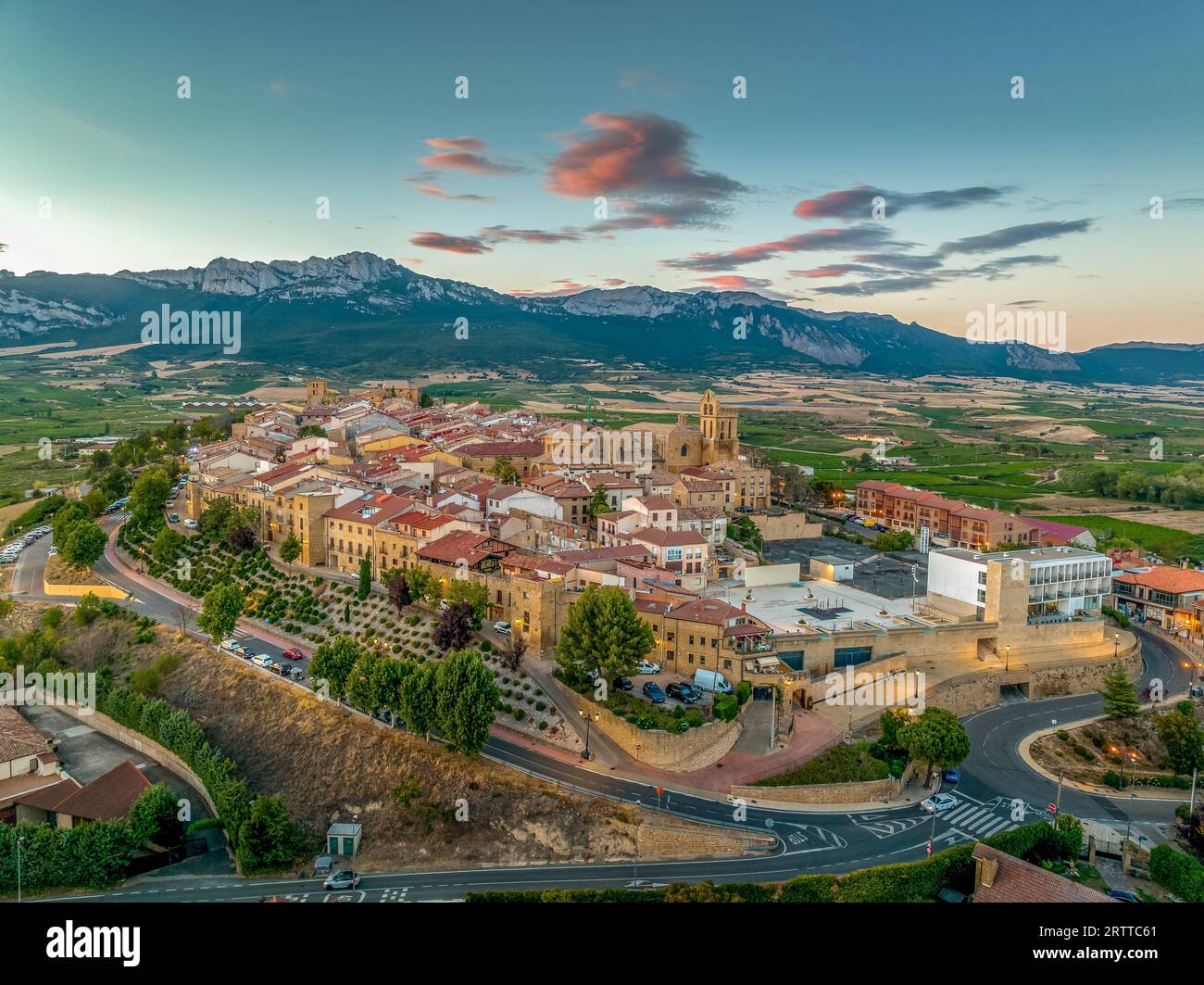 Blick aus der Vogelperspektive auf Laguardia mittelalterliches befestigtes Dorf auf einem Hügel, umgeben von Weingütern in der spanischen Region Rioja, mit farbenfrohem Sonnenuntergang Stockfoto