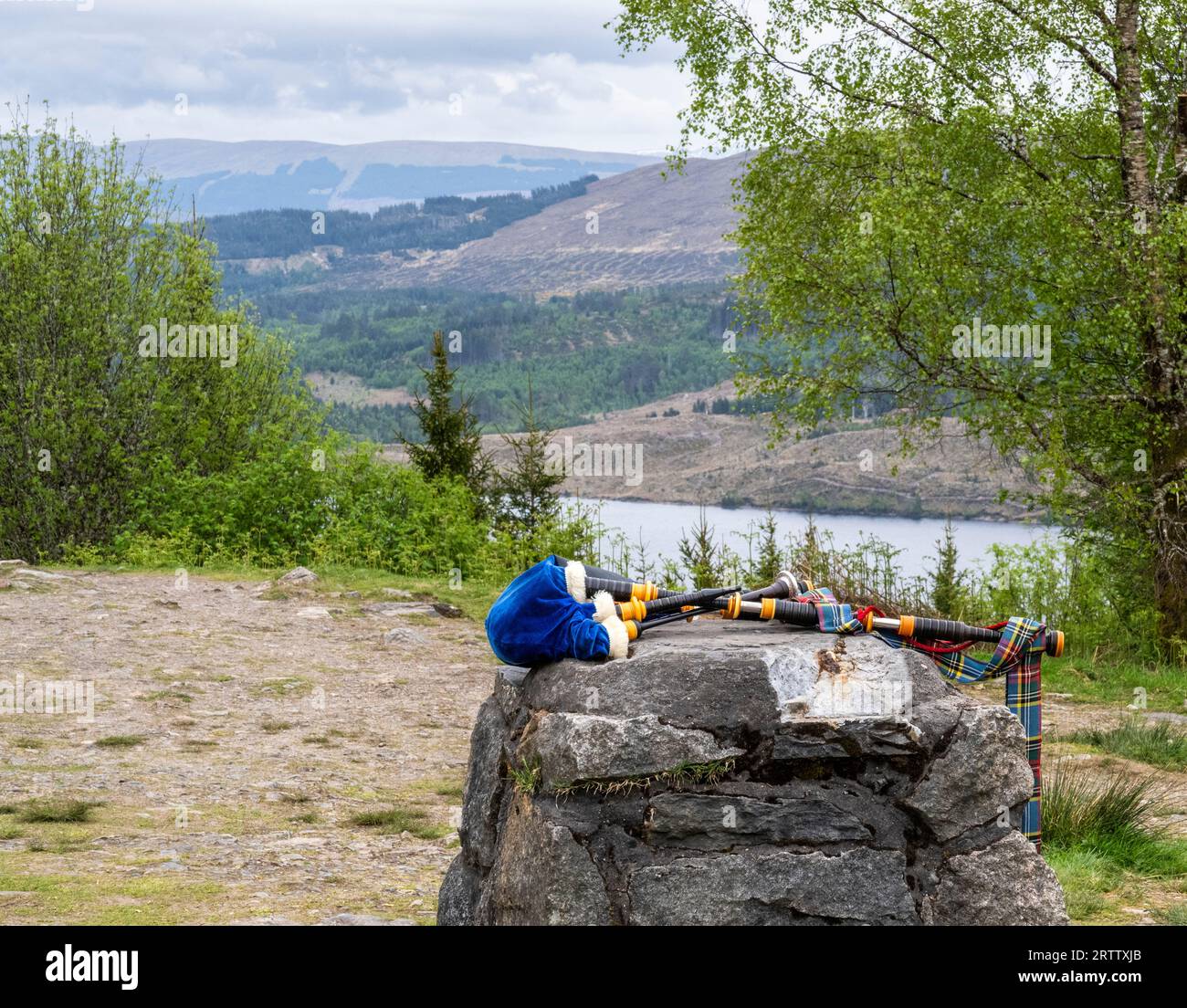 Farbenfrohe Dudelsack-Dudelsack-Dudelsack auf einem Felsen in Schottland Stockfoto