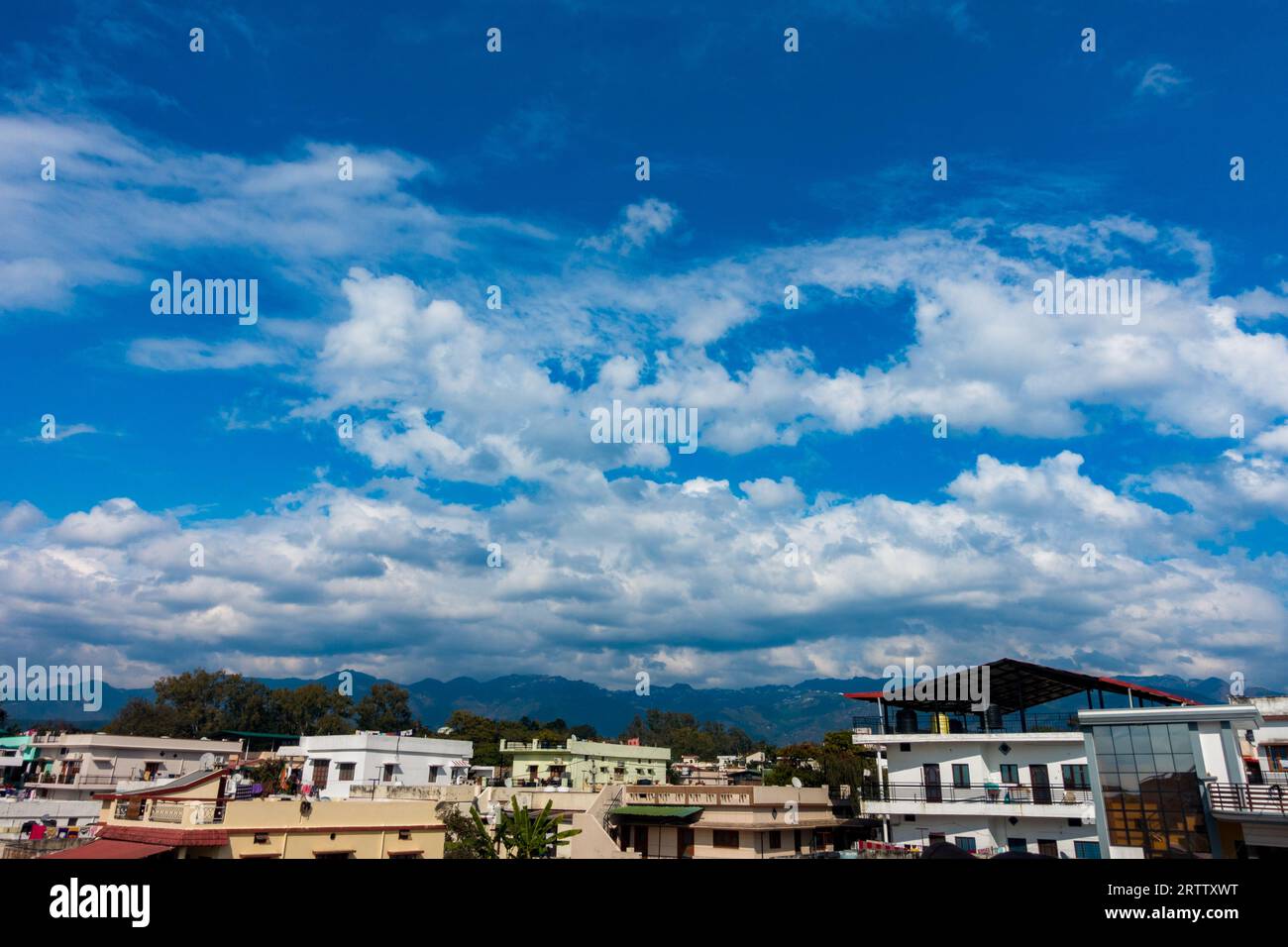 Okt. 2022 Uttarakhand, Indien. Atemberaubende Wolkenlandschaft über Dehradun City, Uttarakhand, mit tiefblauem Himmel, Stadtgebäuden und majestätischen Bergen A Stockfoto